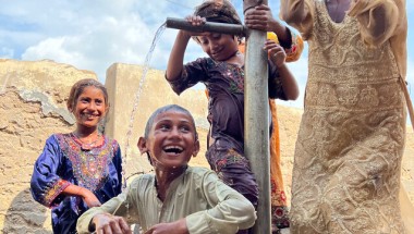 Children are bathing in the water of a village hand pump to cool down during the heatwave. Photo: Arif Shad/Concern Worldwide.