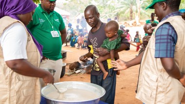 Imenje*, brings his son, Guy*, to receive the nutritious porridge in CAR. Photo: Mussa Uwitonze/Arete/Concern Worldwide.
