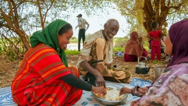 Concern Communications Officer Kalkidan Jabir shares a meal with Hussein Abdulahi Hussein and his wife Nadifa Yusuf and their family in Alloley Kebele, Dollo Bay District in the Somali Region of Ethiopia. Hussein leads a group of 45 farmers who are part of an agriculture group supported by the Hannano Programme. With this support, they received improved variety of seeds, a generator, fuel, water pumps, and training.