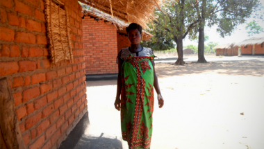  Christina stands outside her home in rural Malawi. Photo taken by Alice Gandiwa.