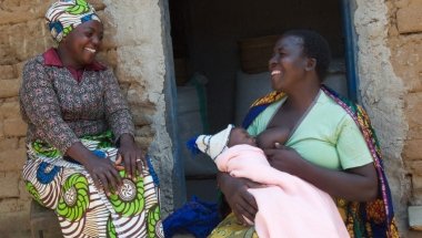Kisa Ngiumba (33), Care Volunteer, with Aida Jugo (43), breastfeeding mother in Tanzania. Photo: Martha Maguire.