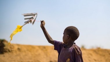 A young boy flies a home made kite on the streets of Juba&#039;s PoC in South Sudan. Photo: Steve De Neef / Concern Worldwide.
