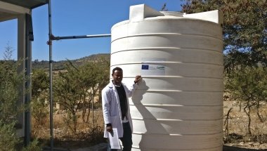 Gedyan Tesfay, Director of the health centre in Tiku, Doga Temben, Ethiopia, beside a water harvesting tank. Photo: Concern Worldwide. 