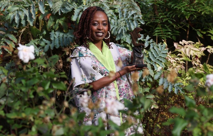 Women of Concern honouree, Berabose Aline Joyce with her award against leave backdrop