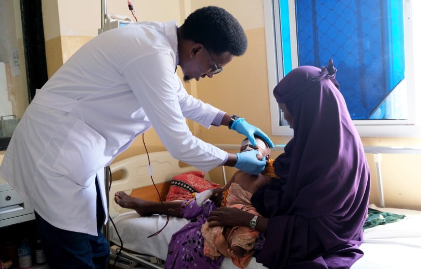 Doctor Muhammad Dek Jama treats Najma* (29) and her baby Cabdi* (18 months) at Banadir Hospital's Stabilisation Centre, Mogadishu. Photo: Hugh Golden/Concern Worldwide