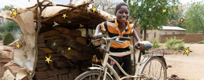 A person smiles in a rural setting