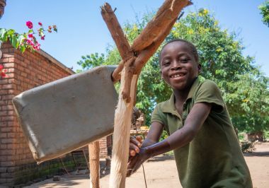 Chabuka, 10, keeps safe with his family’s tippy tap in Malawi. Photo: Concern Worldwide.