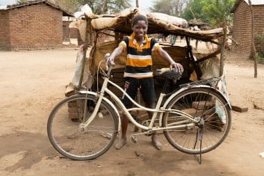 Chifuniro (9) with a bicycle purchased with money from Concern