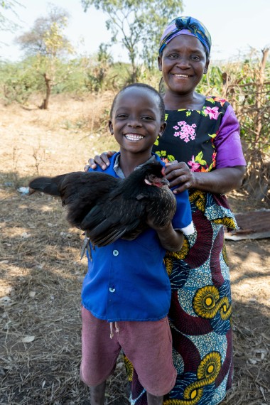 Peterson (9) and mother Ciciliya with a family chicken