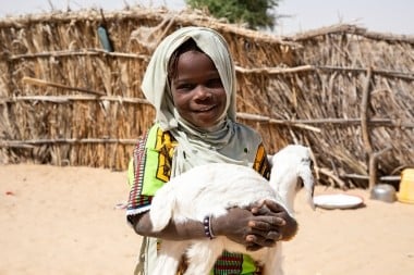 Kaltuma Adam (7) holds up one of her family goats 