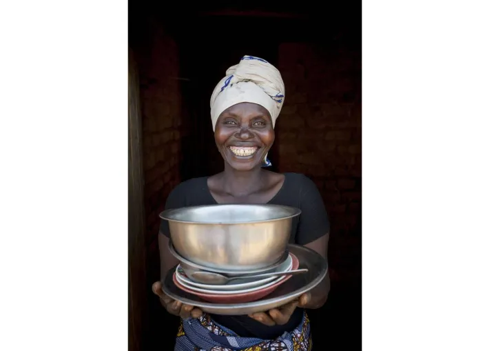 Meresiyana Cimpaya, 40, shows off her new plates, bowls, and pans in Burundi. Photo: Abbie Trayler-Smith / Concern Worldwide Meresiyana Cimpaya, 40, shows off her new plates, bowls, and pans in Burundi. Photo: Abbie Trayler-Smith / Concern Worldwide