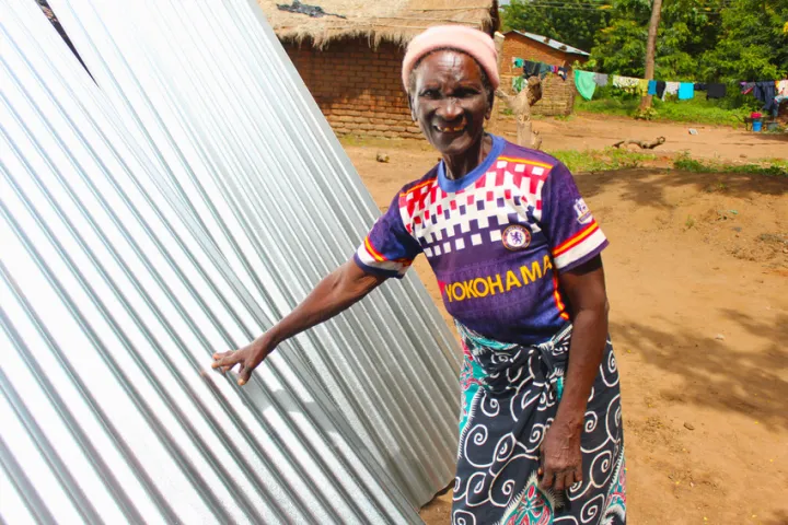 Dorcia (71) with her brand-new waterproof roof sheets. Photo: Jason Kennedy / Concern Worldwide Dorcia (71) with her brand-new waterproof roof sheets. Photo: Jason Kennedy / Concern Worldwide