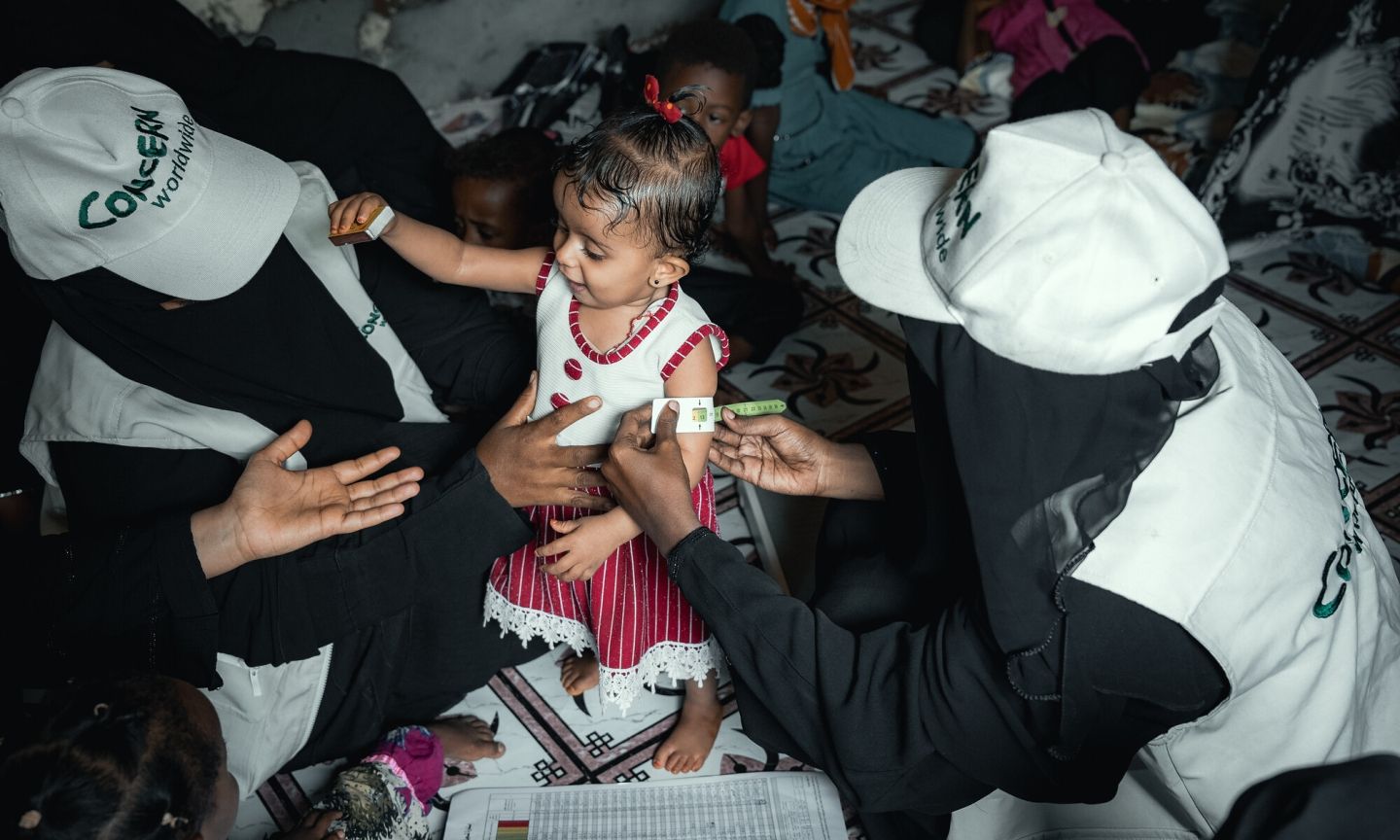 Community Health Volunteer (CHVs) conducting nutrition screening on a child in Yemen.