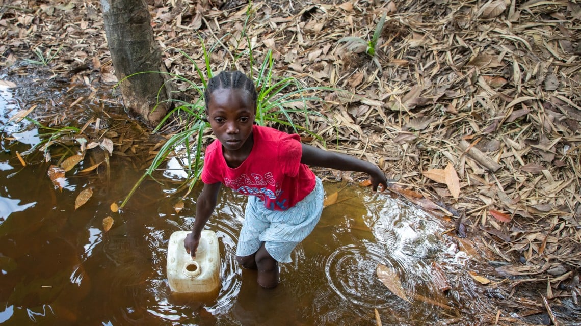 Darling Girl collecting water from the Toe Town creak. During the dry season, this creak is reduced to a couple of inches of murky water. Photo: Gavin Douglas/Concern Worldwide.