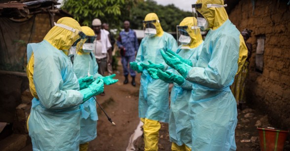 A burial team prays before they collect a corpse in Freetown, Sierra Leone. Photo: Michael Duff / Concern Worldwide.