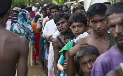 Rohingya men from Myanmar queue at a distribution site at Hakim Para in Cox's Bazar, Bangladesdh. Photo: Kieran McConville / Concern Worldwide.