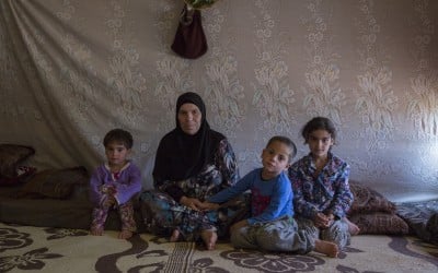 Ayda sits with her grandchildren in her home