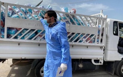 A man in a mask distributes hygiene kits