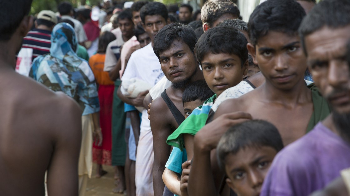 Rohingya men from Myanmar queue at a distribution site at Hakim Para in Cox's Bazar, Bangladesdh. Photo: Kieran McConville / Concern Worldwide.