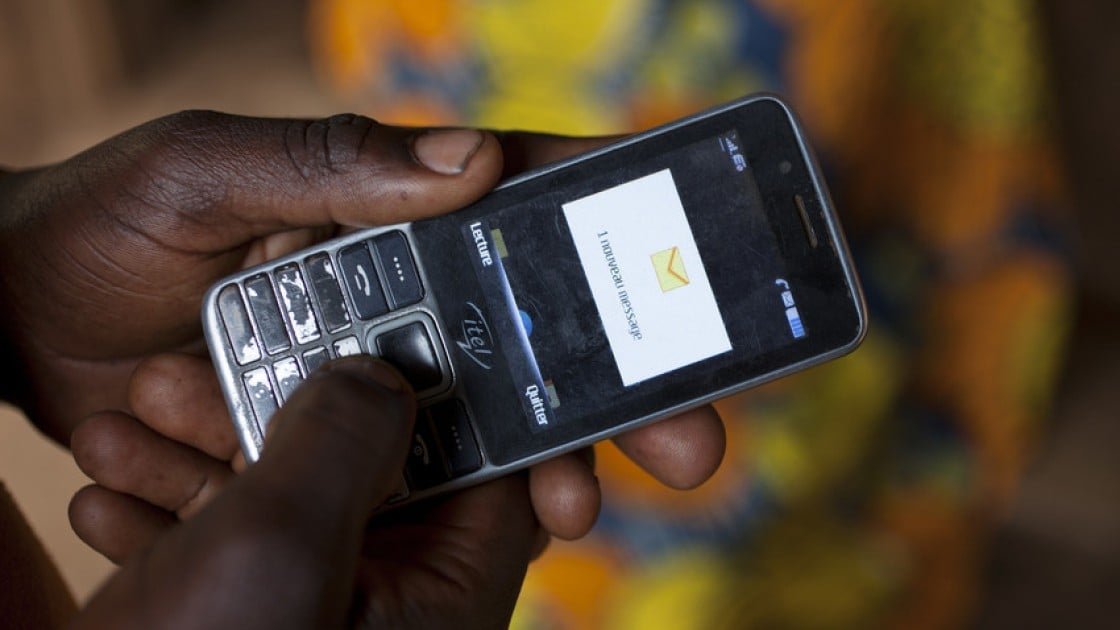 Olivier Irankunda (23) uses his mobile phone at his home in Mabayi, Cibitoke.