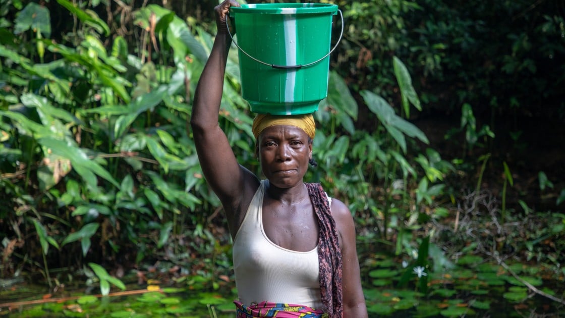 Mother of four, Rebecca Dolley collecting water at Nakai Town's local water source. Midway through the dry season, the only source of water for the town is visibly depleted and dirty. Photo: Gavin Douglas/Concern Worldwide