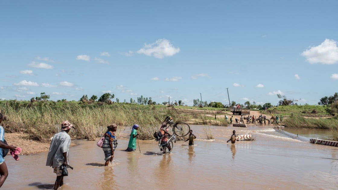 People wade across a river in flood near Nhamatanda, Mozambique. Cyclone Idai has disrupted infrastructure across the country, impacting livelihoods and hampering aid efforts. Photo: Tommy Trenchard / Concern Worldwide.