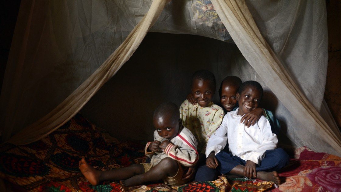 Brothers Salomon (3), David (6), Issa (10) and Selemani (13) in bed with their mosquito net. Photo: Chris de Bode / Concern Worldwide.