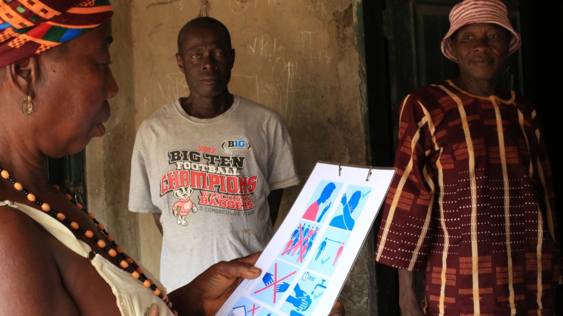 A resident of Bassaia Village looks at a COVID-19 poster.