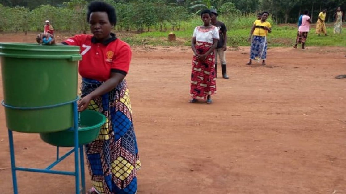 Beneficiaries washing hands in Rwanda as part of an Irish Aid-funded distribution of tools and face masks.