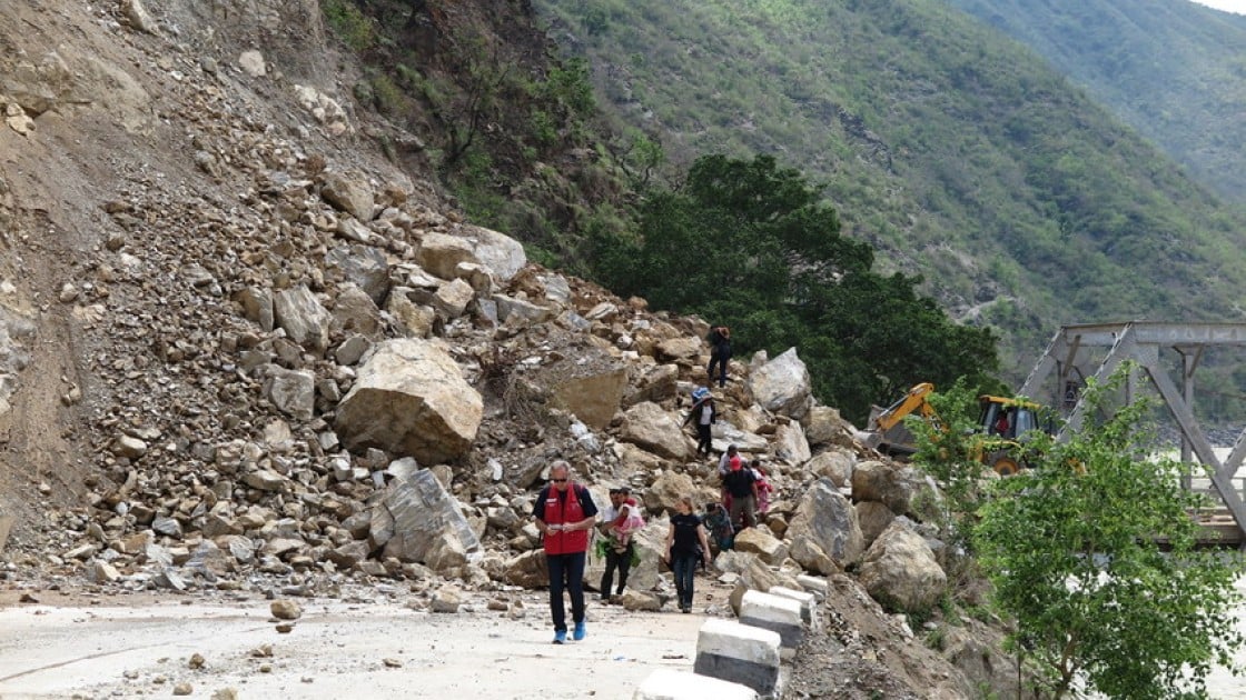 Bulldozers working to re-open a road in Khurkot, Ramechhap after the recent earthquake in Nepal, with a newly-built bridge in the background. Photo taken by Helvetas.