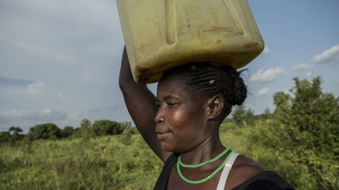 Santina Lalam, a farmer from Agago in Uganda, carries a jerry can on her head to collect water.