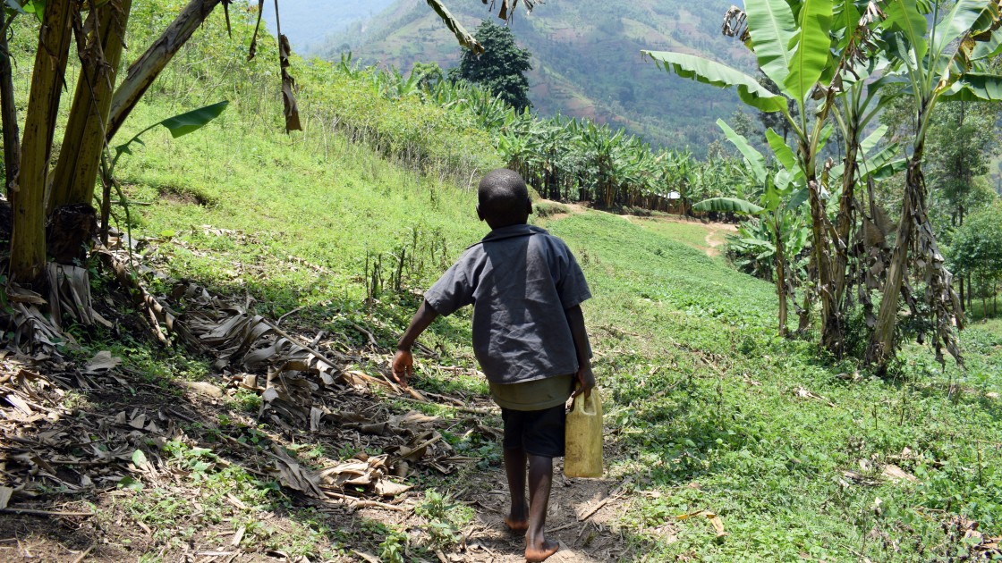 Nishimwe from Burundi makes a two hour journey to school on foot carrying a small container filled with water. Photo: Darren Vaughan/Concern Worldwide.