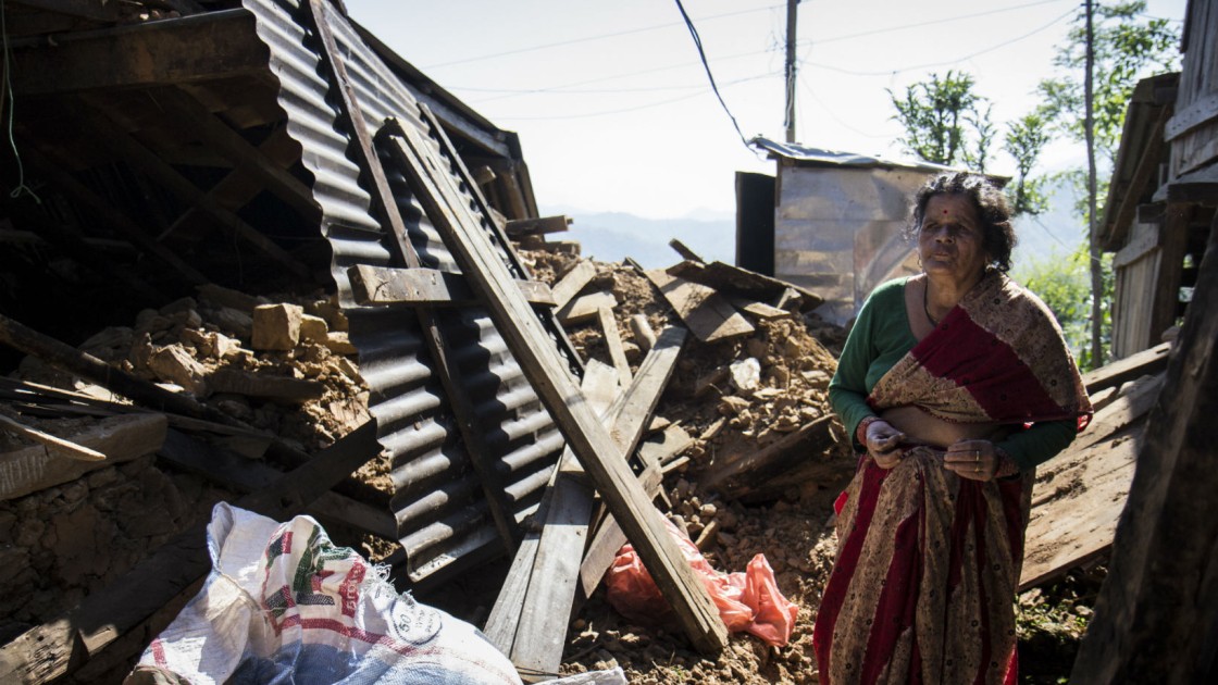 In a Nepalese village, Chandra stands amongst the wreckage of her home. Photo taken by Crystal Wells/Concern Worldwide