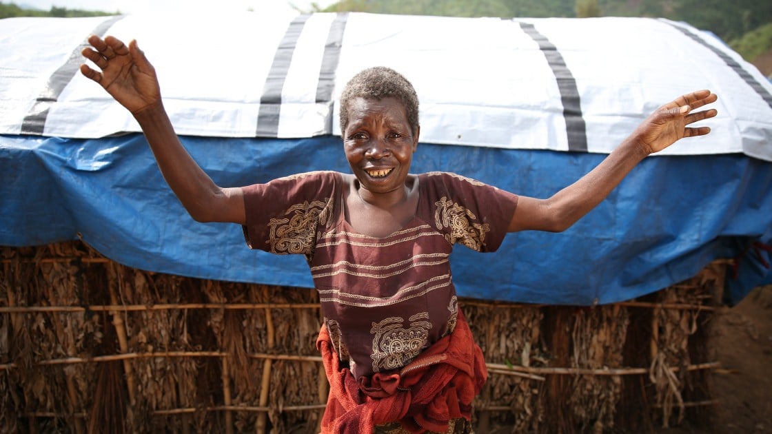 68 year old widow, Kataina Mutoo, shows off her new tarpaulin at Bushani camp in Masisi, DRC, which she received as part of a Concern Worldwide distribution, DRC, 2017. Photo: Jennifer Nolan / Concern Worldwide.