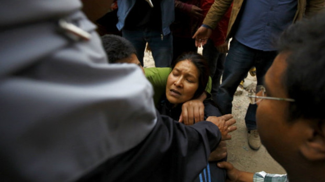 Rescue team member works to dig out the trapped body of a woman from a collapsed house a day after an earthquake in Bhaktapur, Nepal April 26, 2015. Rescuers dug with their bare hands and bodies piled up in Nepal on Sunday after the earthquake devastated the heavily crowded Kathmandu valley, killing at least 1,900, and triggered a deadly avalanche on Mount Everest. REUTERS/Navesh Chitrakar