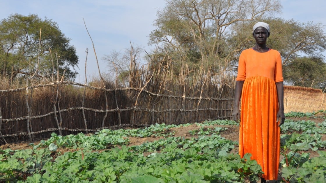 Namia stands proudly next to the vegetable garden she grew with the help of Concern. Photo taken by Deborah Underdown.