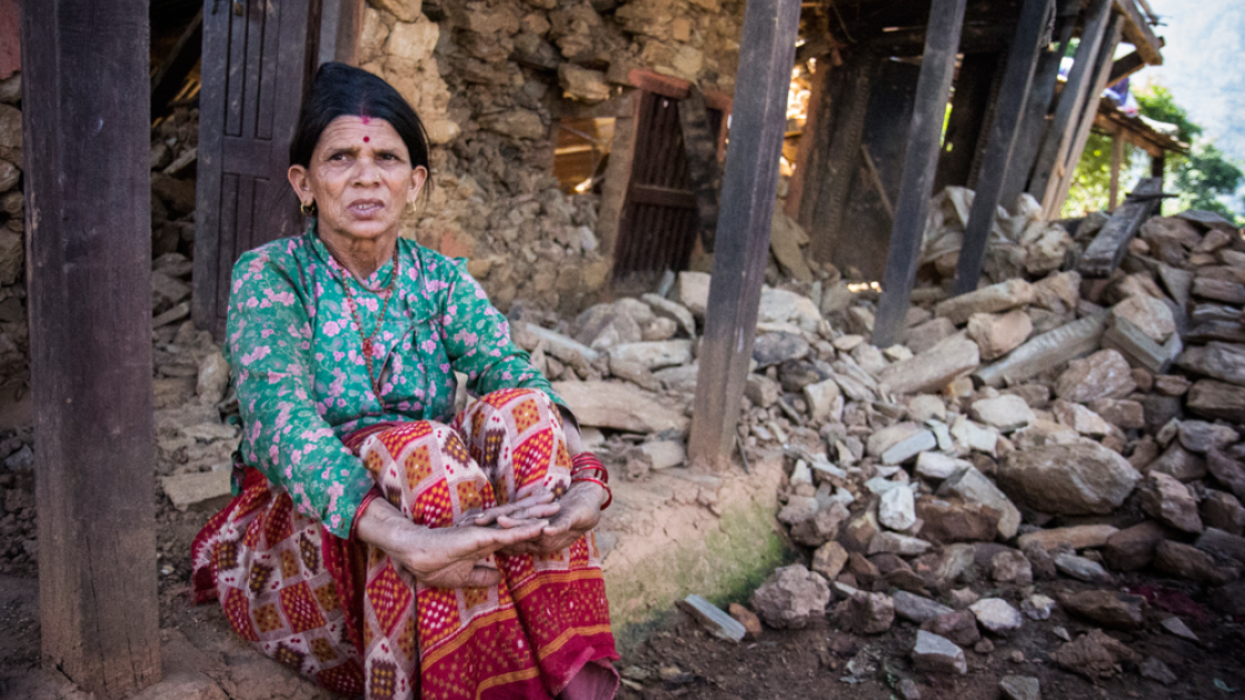 Tulasa Aryal sits on the porch of her earthquake-ravaged home in Bakrang, a village near the epicenter of the earthquake. Photo taken by Crystal Wells/Concern Worldwide.