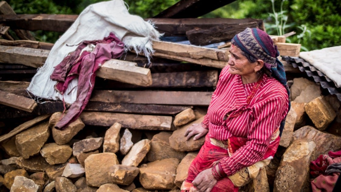 In the Nepalese village, Kukhreta, a woman sits on the rubble of her recently-destroyed home. Photo taken by Crystal Wells/Concern Worldwide
