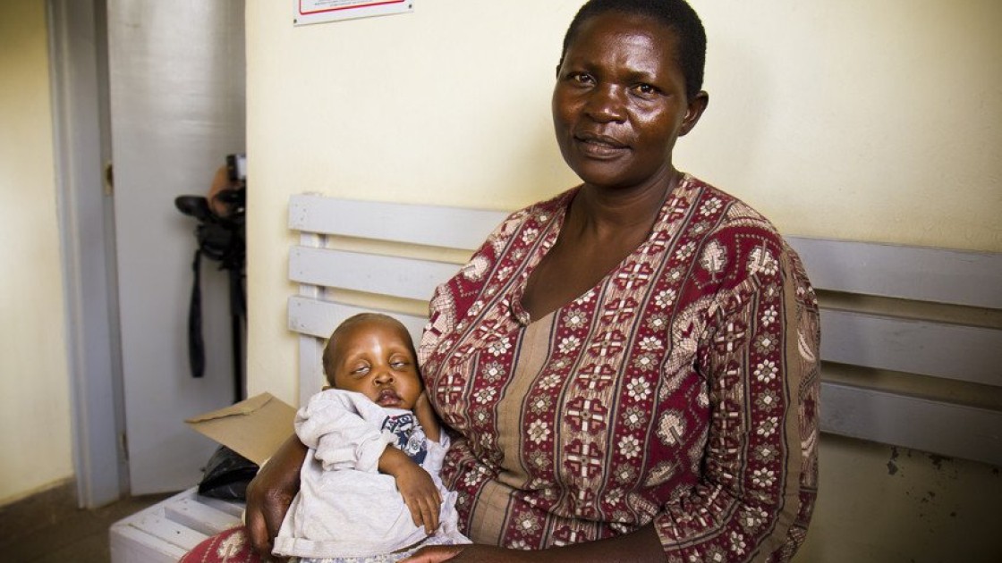 Esther, 40, cradles her child, Euticus, one year three months, at Baraka Health Centre in the heart of Mathare slum. Euticus, who has severe malnutrition as well as tuberculosis, is receiving treatment at the health centre, which is one of 107 clinics supported by Concern Worldwide across eight slum communities in Nairobi and Kisumu. Photo taken by Crystal Wells / Concern Worldwide.