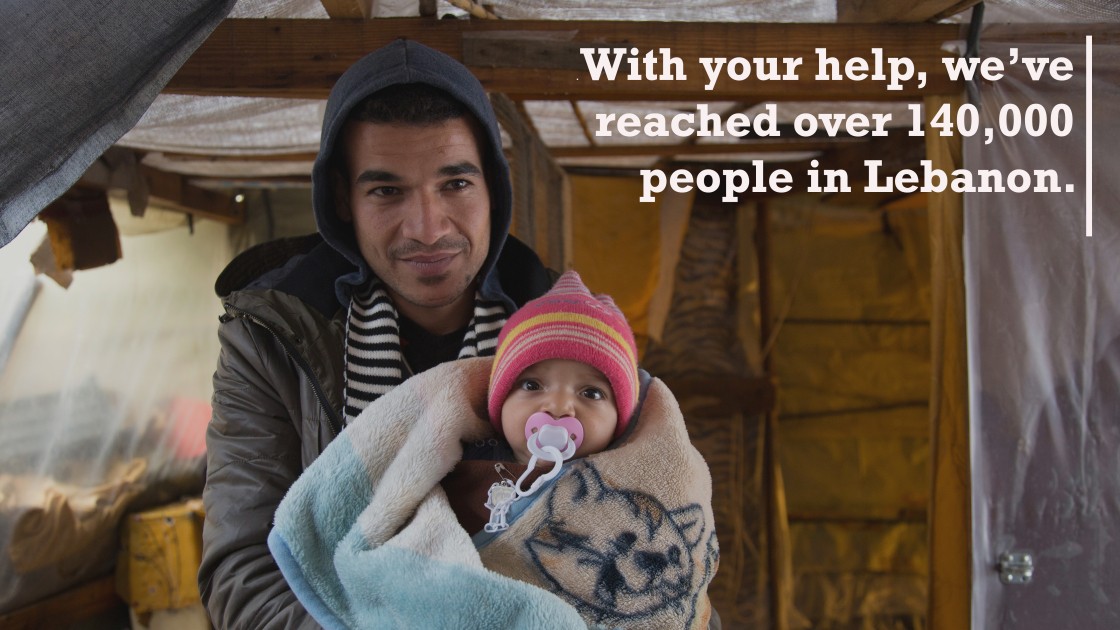 Syrian refugee Ahmad, 22, holds his cousin's baby Amin, 5 months, as he stands at the entrance of his tent in an informal tented settlement in Mohamara, in Akkar, north of Lebanon. Photo: Dalia Khamissy/Concern Worldwde.