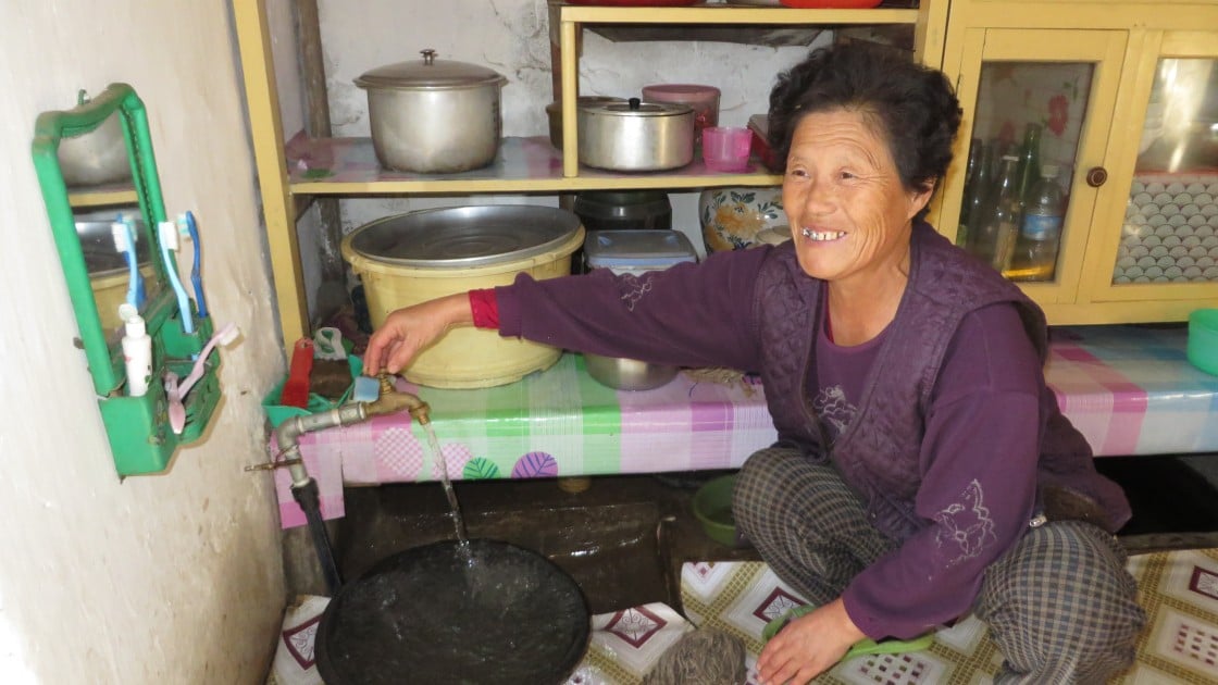 Jong Hyon Hwa turns on a tap with water supplied by Concern Worldwide’s gravity fed water supply system in Daesong, Singye, North Hwanghae, Democratic People’s Republic of Korea. Photo taken by Pae Ryong Il / Concern Worldwide.