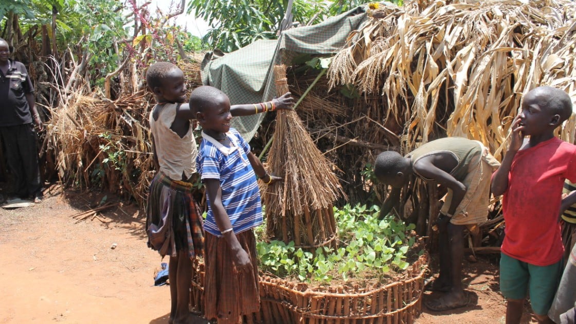 Young children proudly display a keyhole garden.