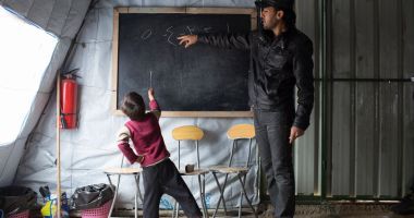 Syrian refugee boy studying in an informal classroom