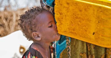 Young girl drinking from a tippy-tap in Somalia