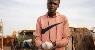 Younous holds up one of his pigeons at his shelter in a refugee camp in Eastern Chad. Photo: Eugene Ikua/Concern Worldwide