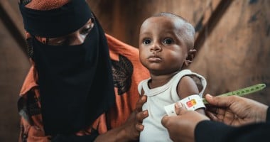 Community health worker assessing infant in Yemen 