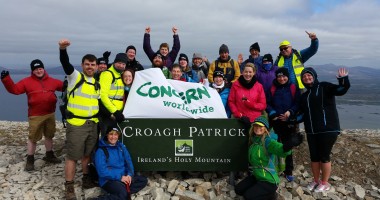 Group of climbers celebrate reaching top of Croagh Patrick