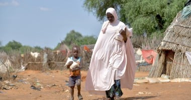 Baria Moumouni carries home packages of fortified flour with her child, distributed by Concern in Tanawara village, Niger. Photo: Concern Worldwide