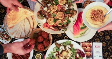  Dinner part scene shown from above. People share Palestinian food. 