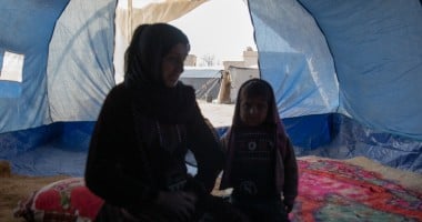 Amira* sits with her youngest child in a tent she calls home, she is one of the 11 million people who have been displaced within Syria during 15 years of conflict. Photo: Gavin Douglas/Concern Worldwide